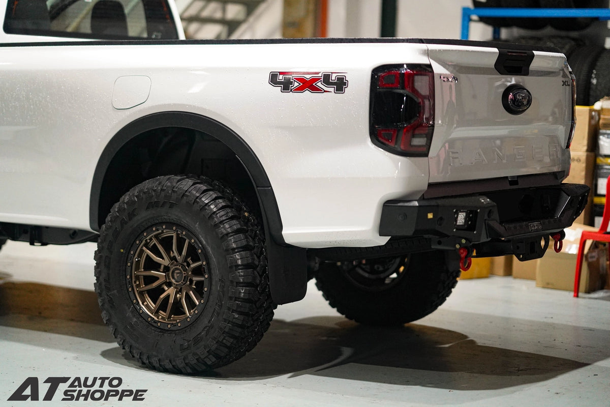 White truck with 4x4 badge in a garage setting