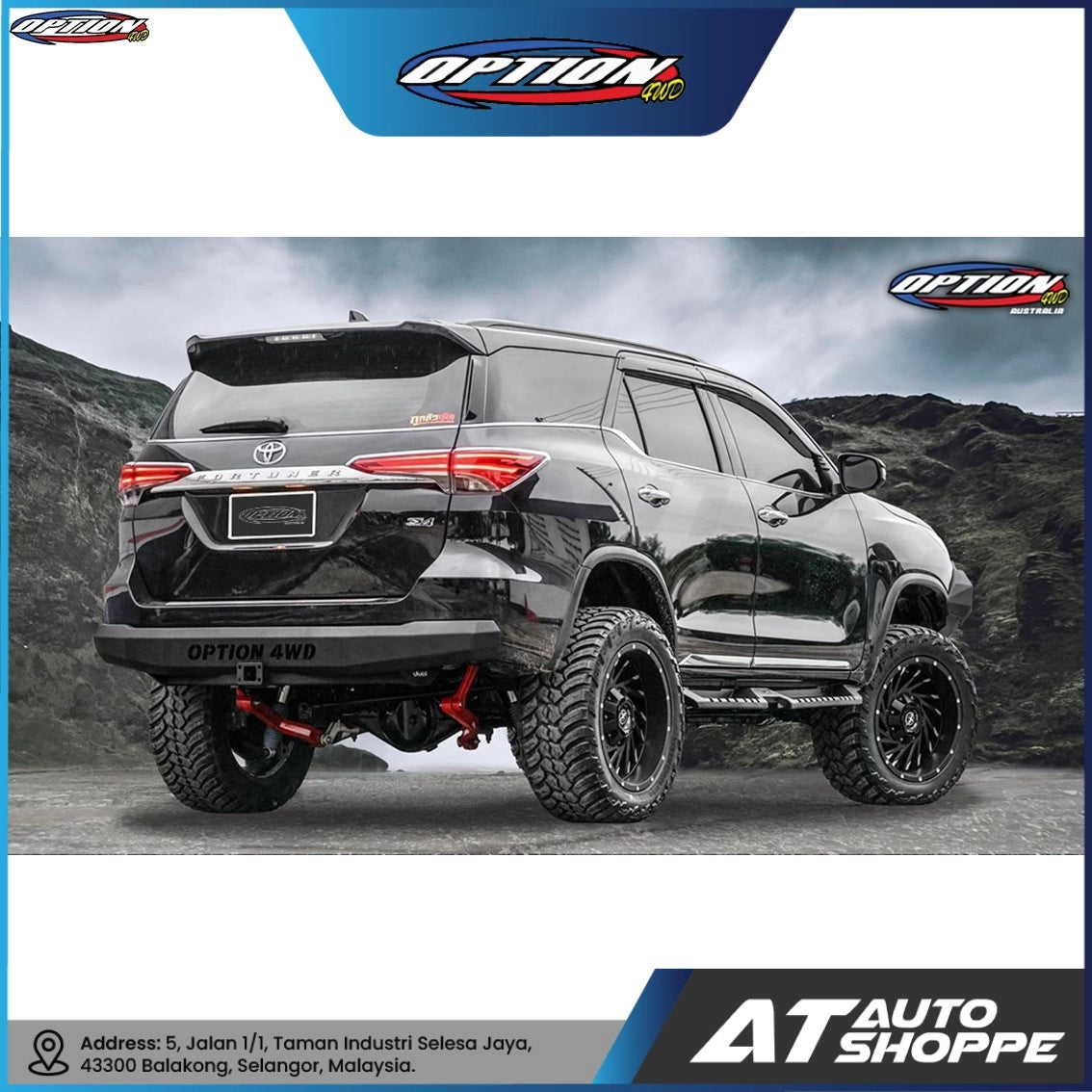 Black SUV with large tires on a mountainous road, featuring Option 4WD and AT Auto Shoppe logos.