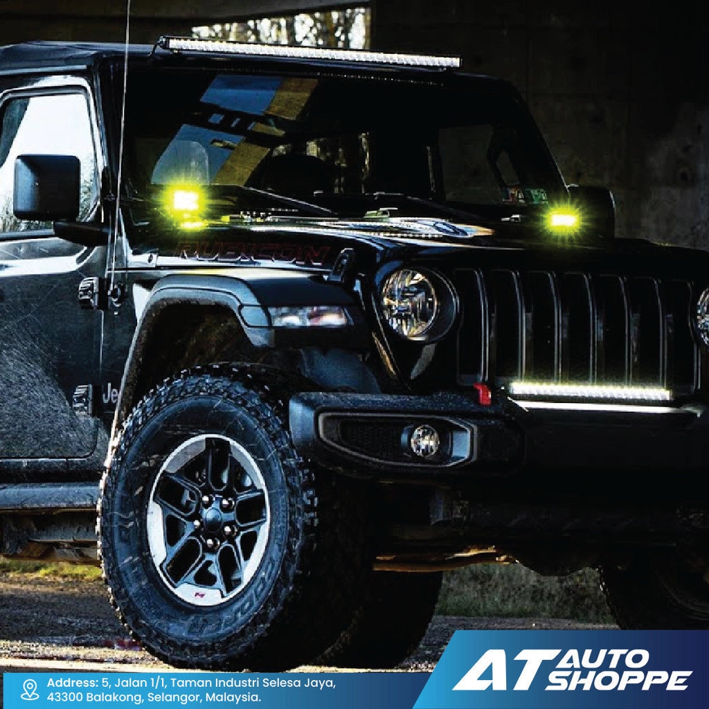 Black Jeep Wrangler with additional lights on a dark background, featuring AT Auto Shoppe branding.