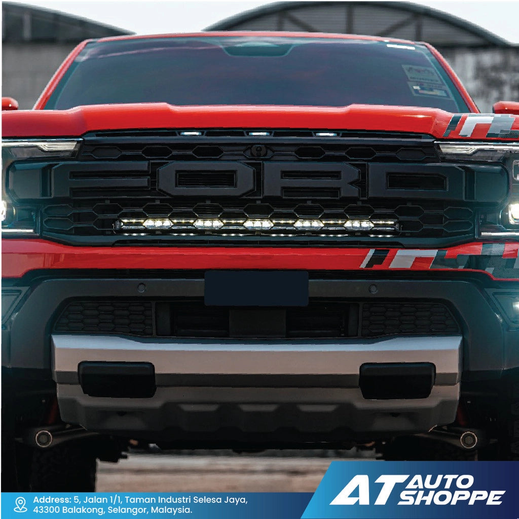 Front view of a red Ford truck with visible branding at AT Auto Shoppe.