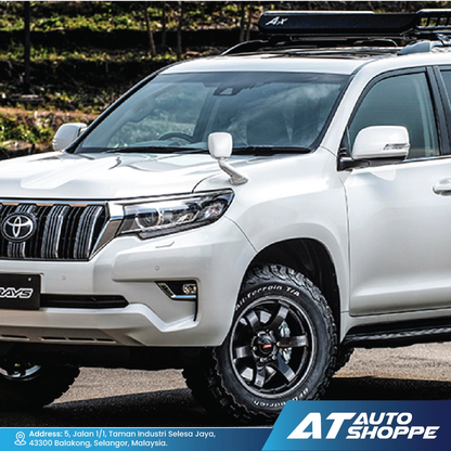 White Toyota SUV with roof rack on a road, featuring AT Auto Shoppe branding.