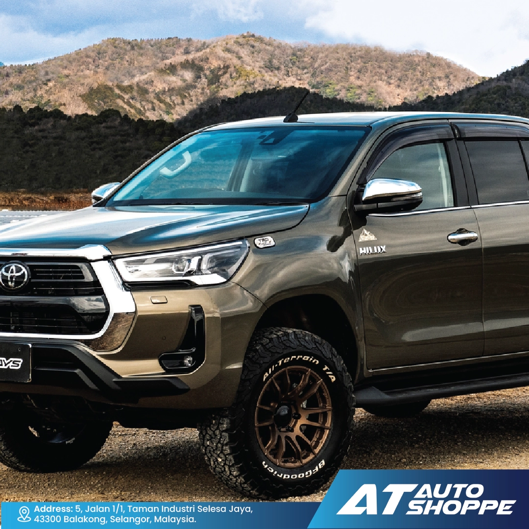 Toyota SUV parked in a mountainous area with 'AT Auto Shoppe' branding.