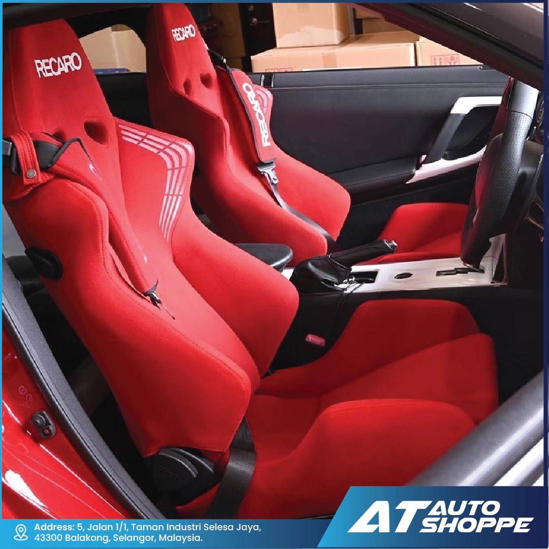 Red racing seats with Recaro branding inside a car, showing the interior of a vehicle.