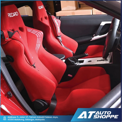 Red racing seats with Recaro branding inside a car, showing the interior of a vehicle.
