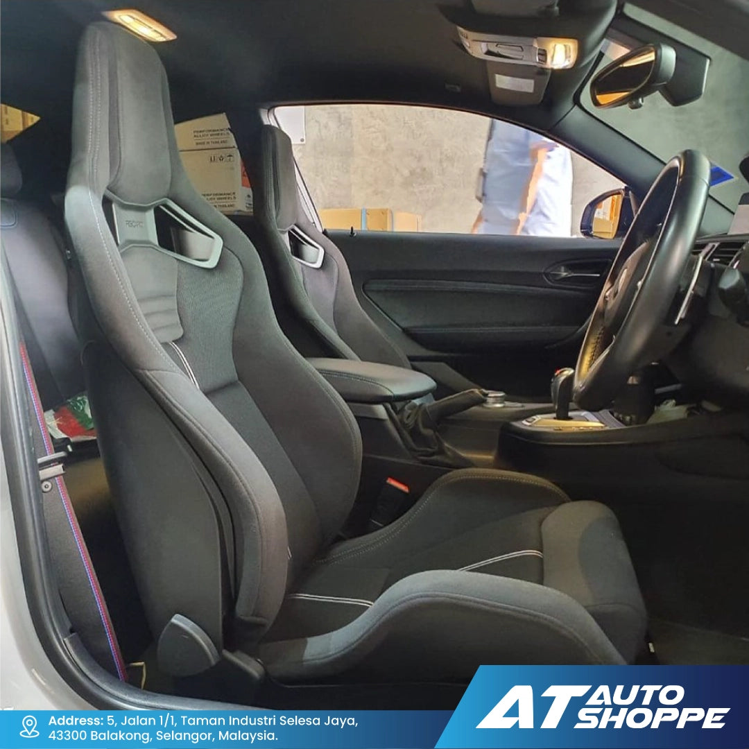 Car interior with Recaro grey seats and dashboard, showing the steering wheel and gear shift.