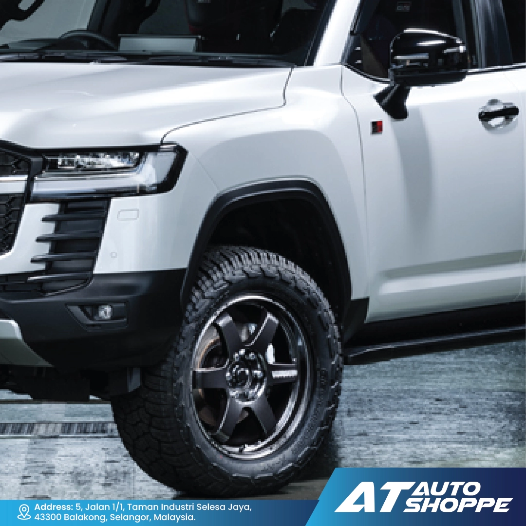 White SUV with black wheels on a gray surface, featuring AT Auto Shoppe branding.