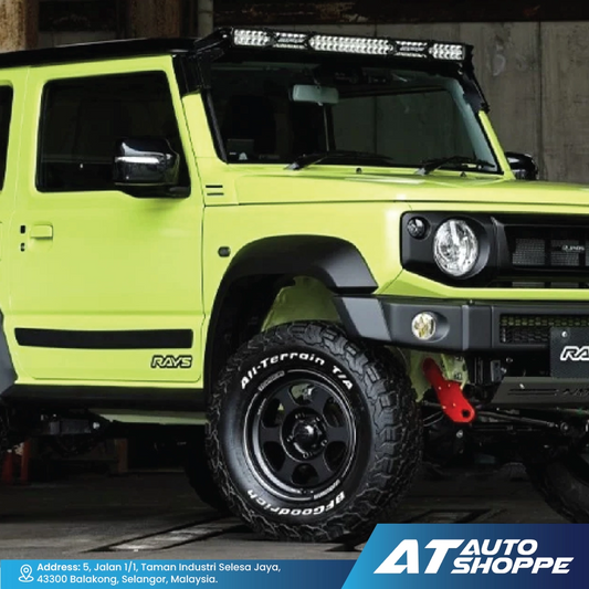 Green off-road vehicle with additional lights and tires on a concrete surface, featuring AT Auto Shoppe branding.