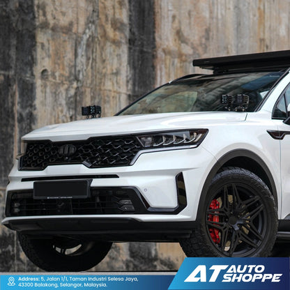 White SUV with black and red accents against a textured wall, featuring AT Auto Shoppe branding and Rigid Industries D-Series Midnight Edition Spotlight.