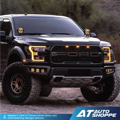 Black Ford truck with off-road tires on a dirt road, featuring the AT Auto Shoppe logo.