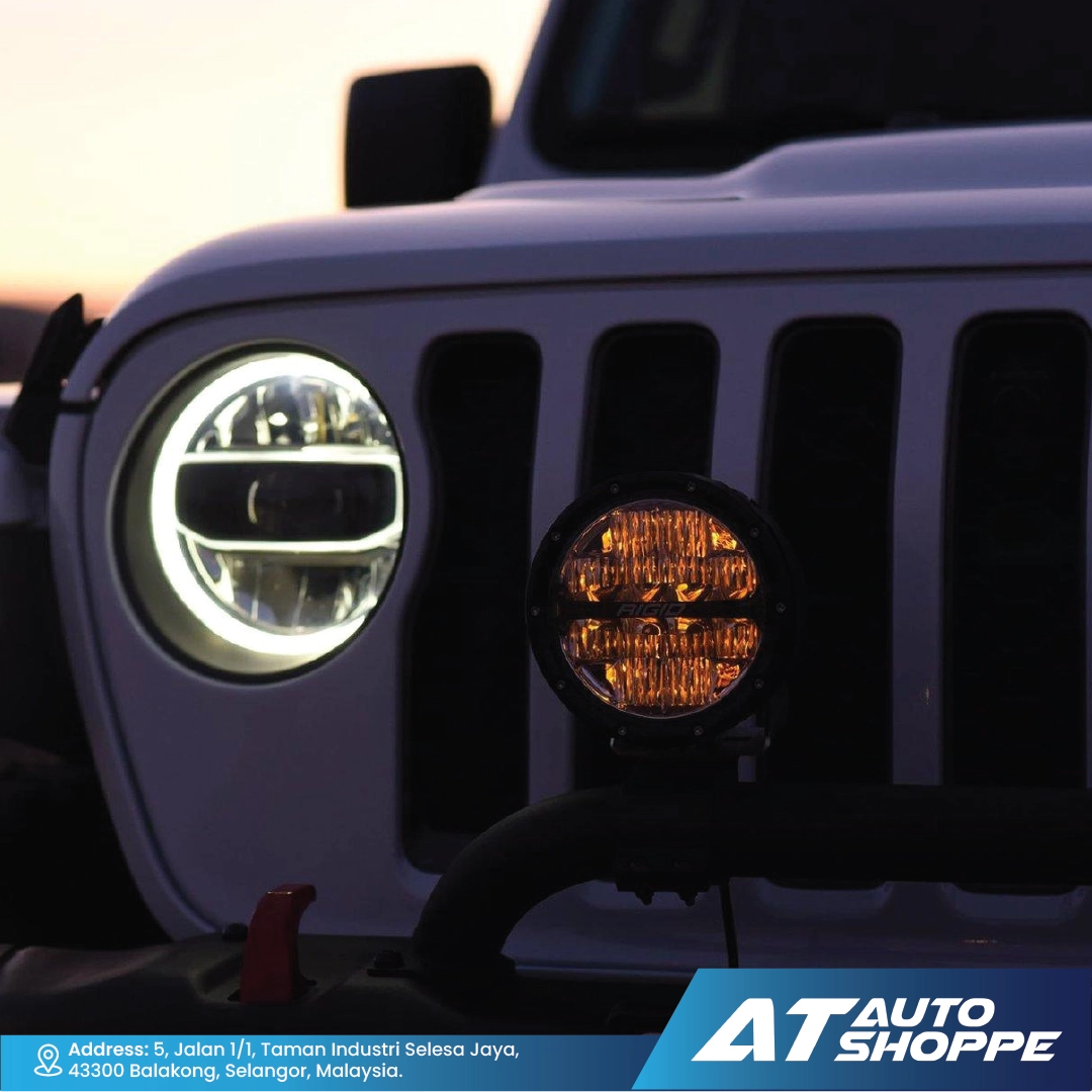 Close-up of Rigids headlight and fog light with 'AT Auto Shoppe' branding.