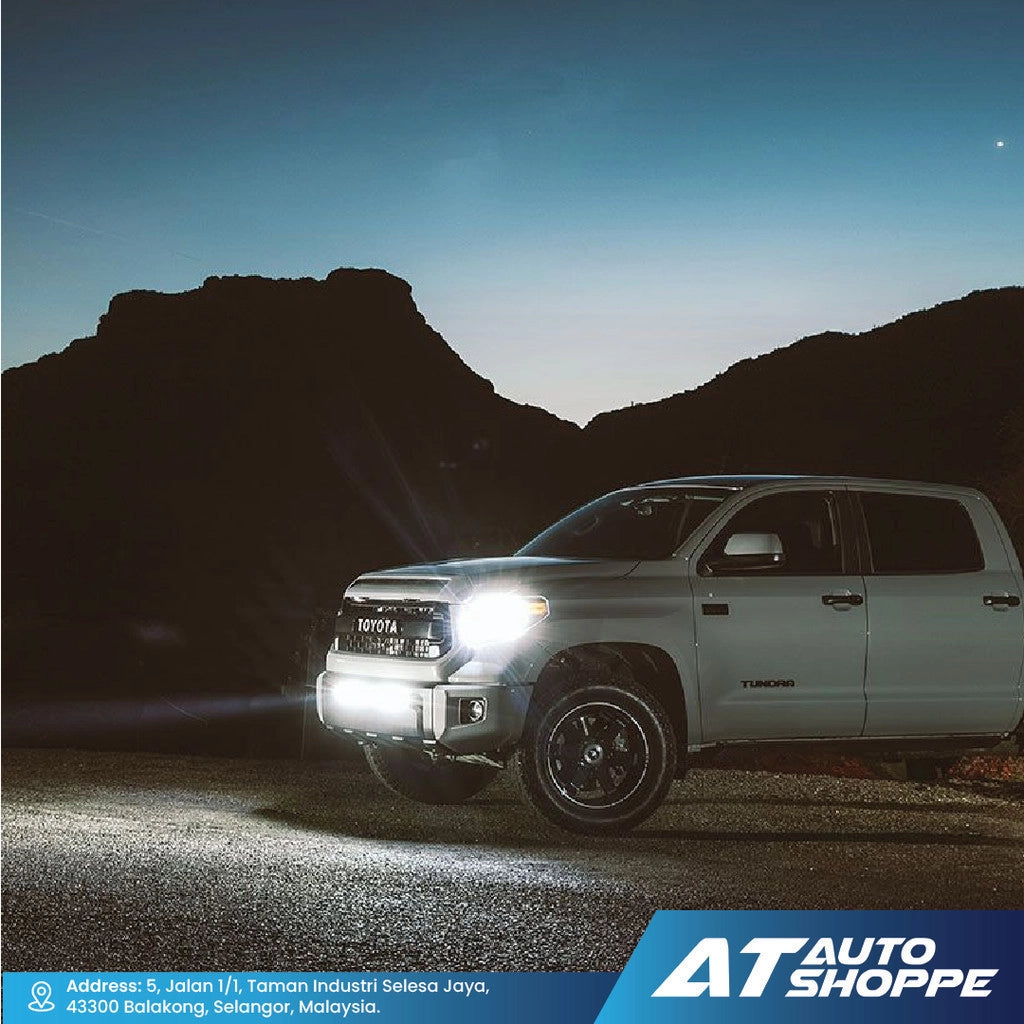 White Toyota truck with Rigid headlights on in a mountainous area at night, featuring AT Auto Shoppe branding.