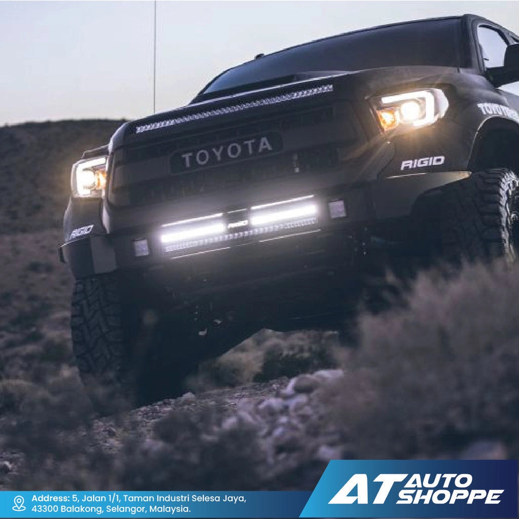 Toyota truck on a dirt road with 'AT Auto Shoppe' branding at the bottom.