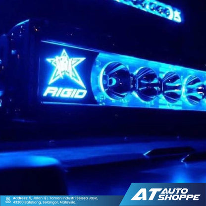 Rigid Industries LED light bar with star logo on a vehicle, illuminated with blue light, branded with AT Auto Shoppe.