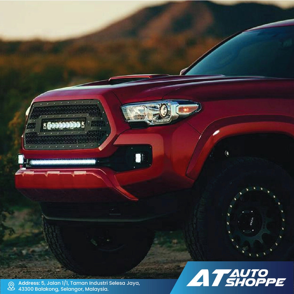 Red pickup truck with off-road tires in a natural setting, featuring AT Auto Shoppe branding with Rigid SR Series Light Bar