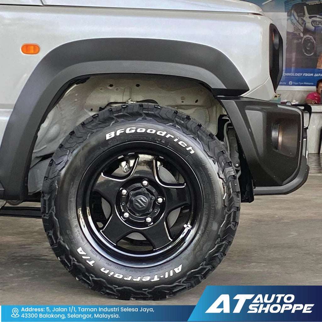 Close-up of a BFGoodrich all-terrain tire on a vehicle with 'AT Auto Shoppe' branding.