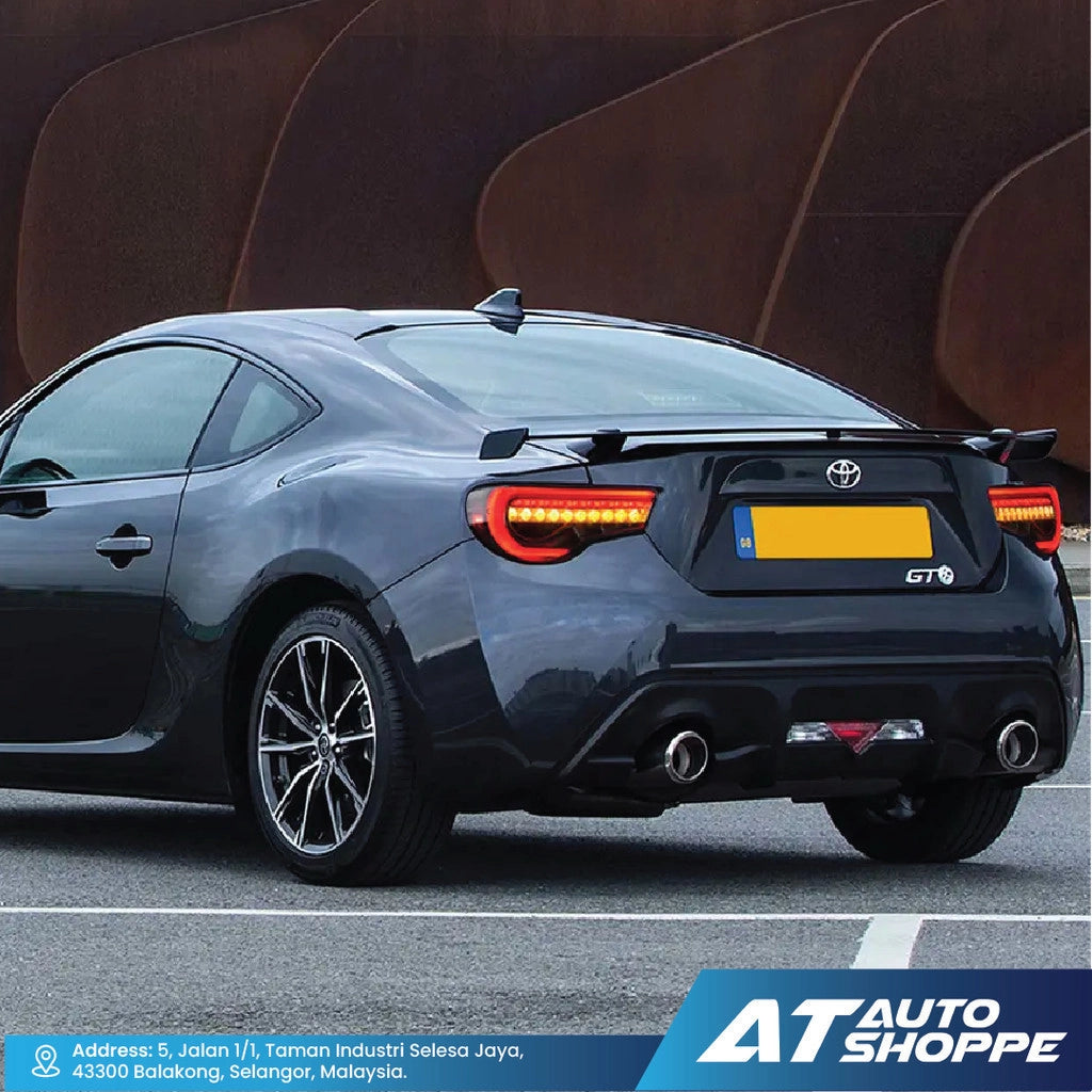 Black Toyota car with 'GT' badge on a road, featuring AT Auto Shoppe branding.