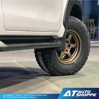 Close-up of a vehicle tire with a VLF bronze rim on a concrete surface, featuring the AT Auto Shoppe logo.