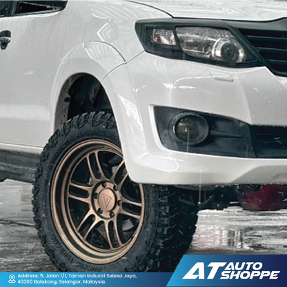 Close-up of a white vehicle with a detailed view of the VLF wheel and front bumper, featuring the AT Auto Shoppe logo.