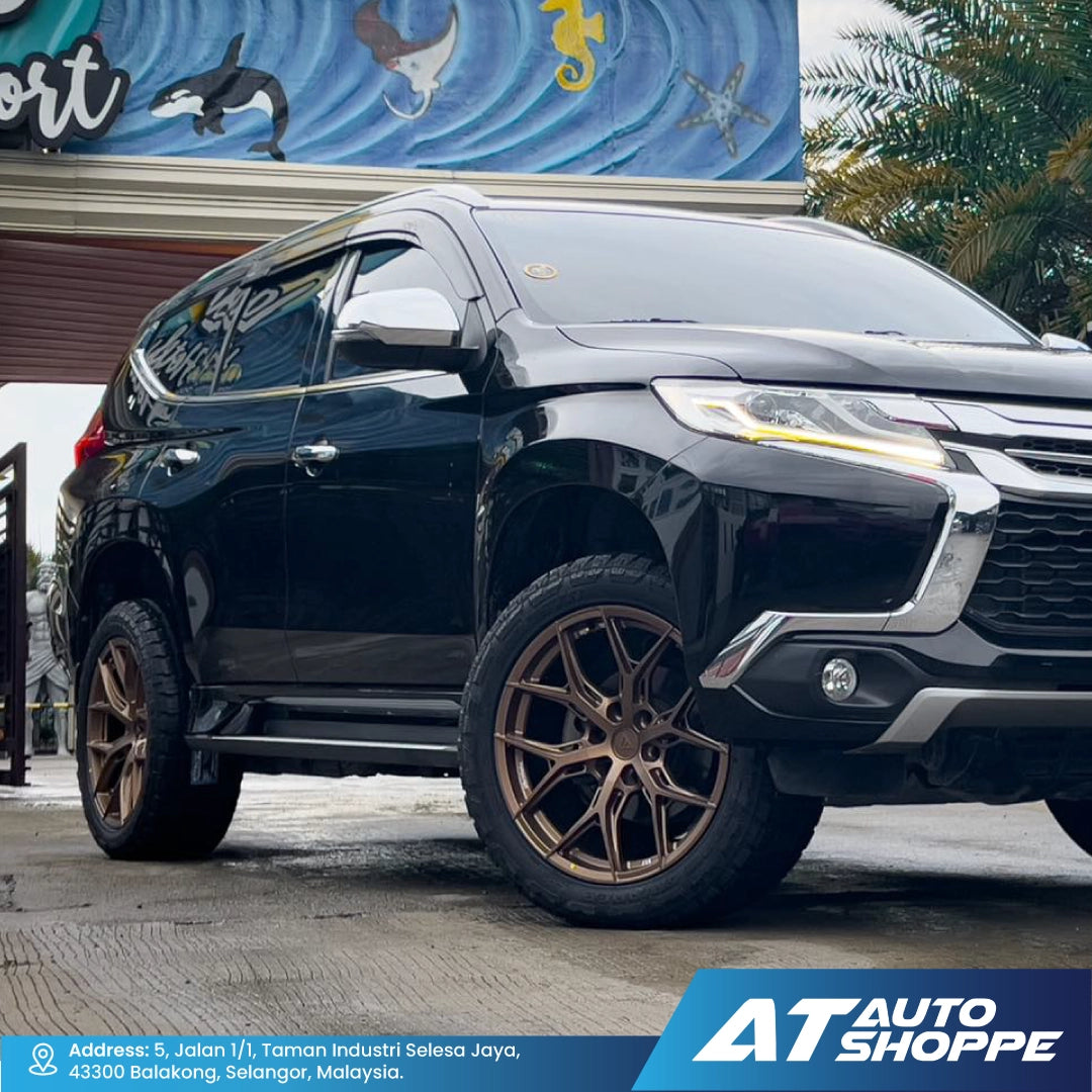 Black SUV with VLF bronze rims parked in front of a building with a signboard.