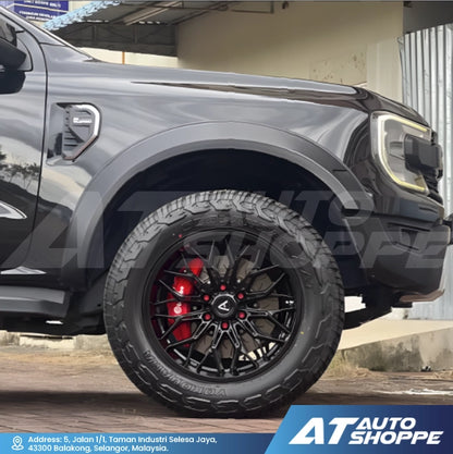 Close-up of a black truck with Vampire rim on a road, featuring AT Auto Shoppe branding.