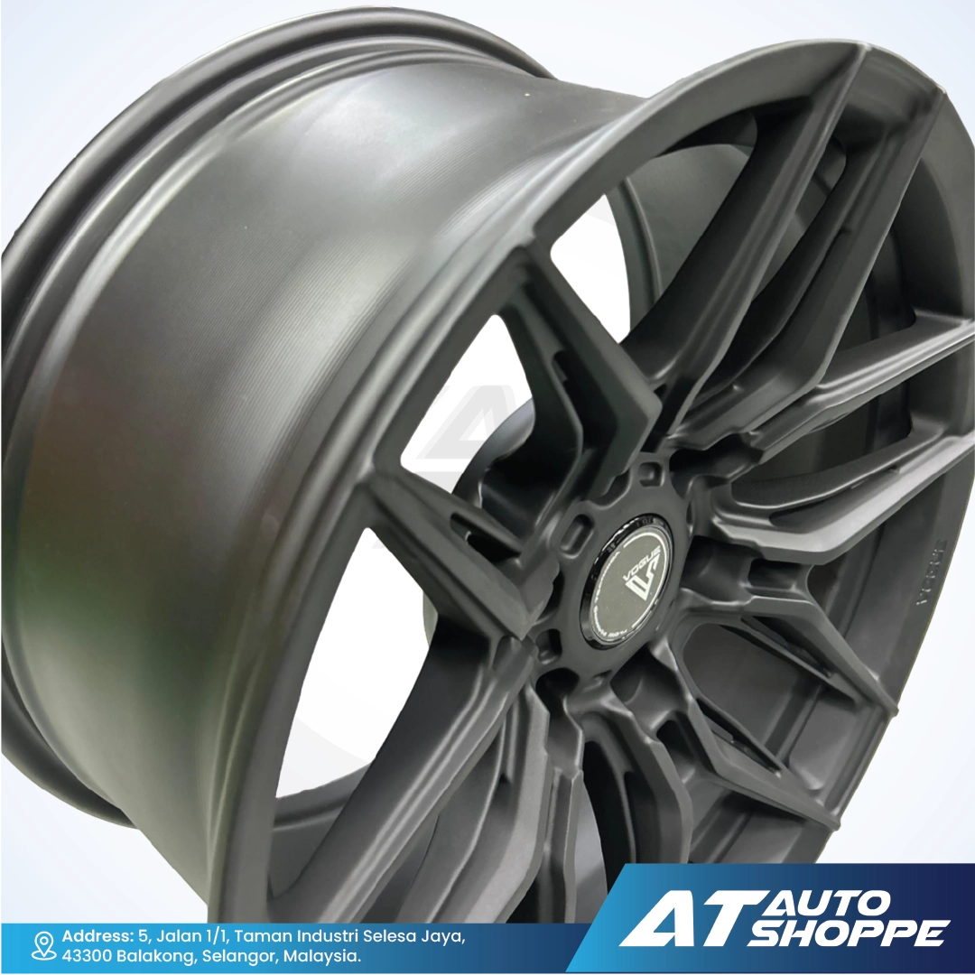 Close-up of Vogue black alloy wheel with a visible brand logo on a white background