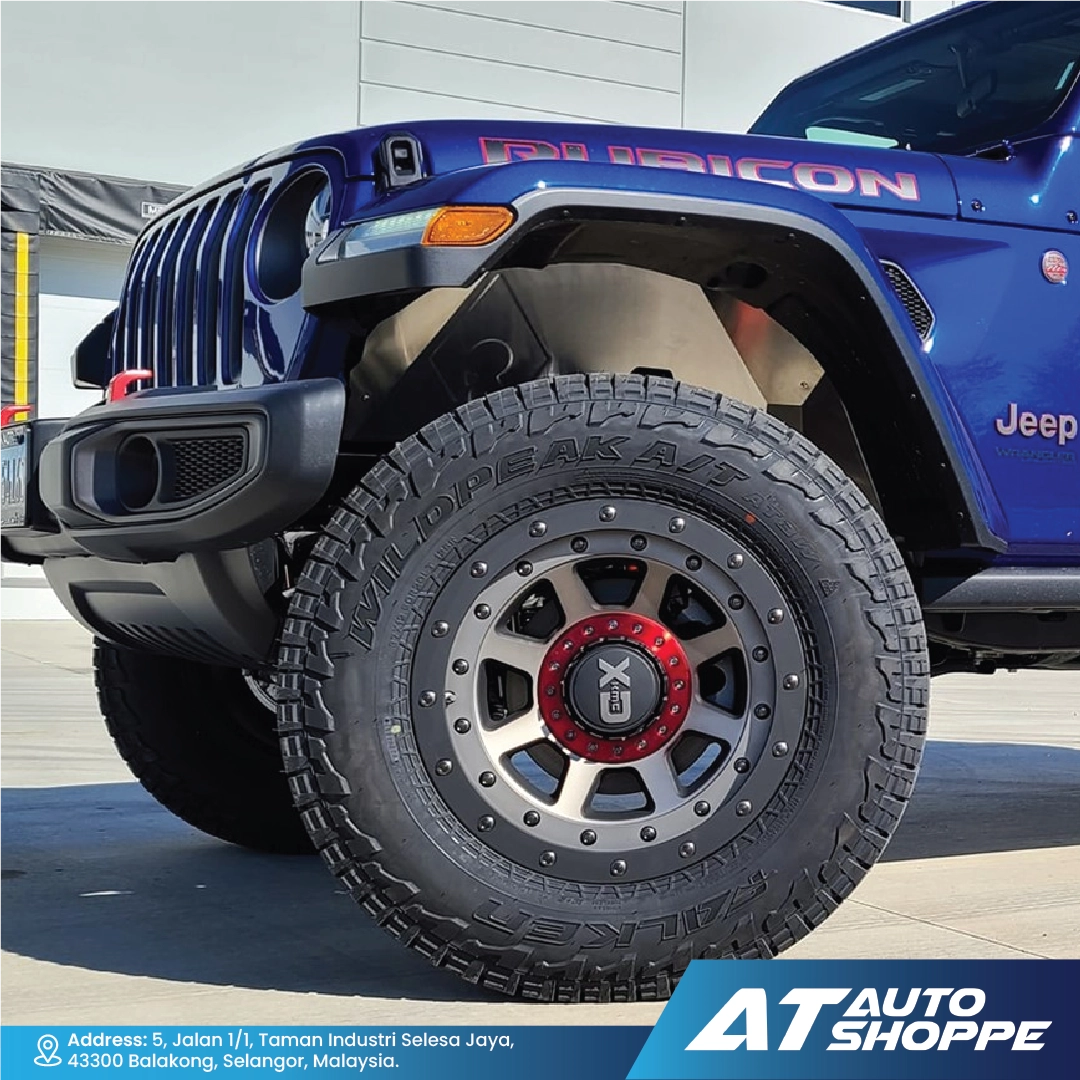 Close-up of a blue Jeep with a detailed tire and  wheel, featuring the brand 'AT Auto Shoppe'.