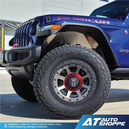 Close-up of a blue Jeep with a detailed tire and  wheel, featuring the brand 'AT Auto Shoppe'.