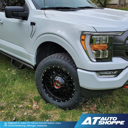 White pickup truck with black XD wheels on grass, featuring AT Auto Shoppe branding.