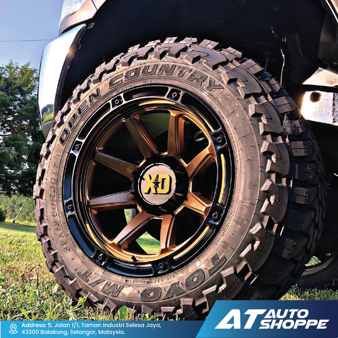 Off-road tire with XD rim on a vehicle, set against a natural background.